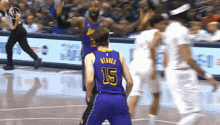 a basketball player wearing a number 15 jersey stands on the court