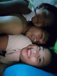 a man and two girls are laying on top of each other on a bed