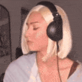 a woman wearing headphones and a wig is looking down .