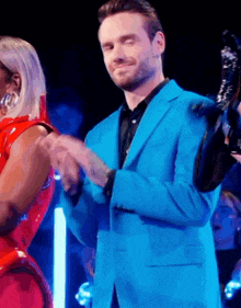 a man in a blue suit shakes hands with a woman