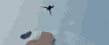 a man in a spiderman costume is jumping off a cliff .