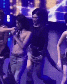 a group of women are dancing on a stage in front of a screen