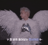 a man in a white angel costume has asian writing on the bottom