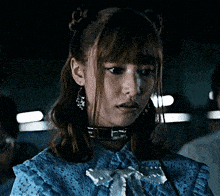 a woman with a choker around her neck is wearing a blue top