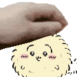 a hand is holding a cartoon character with a face on it .
