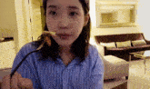 a woman in a blue and white striped shirt is eating a piece of food with a fork