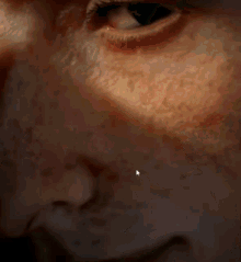 a close up of a person 's face with a white arrow pointing to a spot