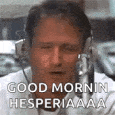 a man wearing headphones is talking into a microphone and saying good morning .