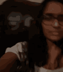 a woman wearing glasses and a white shirt is sitting in a chair