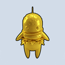 a gold statue of a hamburger with a toothpick in its mouth
