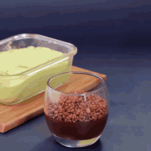 a glass filled with chocolate and rice krispies next to a glass filled with green ice cream