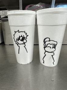 two styrofoam cups with drawings of a man and a woman on them