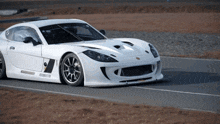 a white sports car is driving down a road