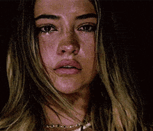 a close up of a woman 's face with a tear running down her face .
