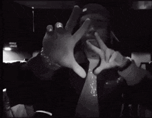 a black and white photo of a man making a hand gesture with his hands