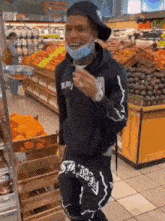 a man wearing a mask is dancing in a grocery store .
