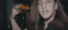 a man with long hair and a ring on his finger