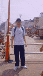 a man wearing a lacoste shirt is standing on a bridge
