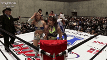 two women in a wrestling ring with the word stardom on the side