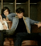 a man in a denim jacket sits on a couch
