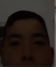 a close up of a man 's face in the dark with his eyes closed