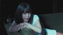 a woman laying on a green couch with a white shirt on that says angels