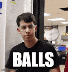 a young man wearing glasses and a black shirt with the word balls on it