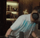 a man wearing headphones and a white shirt stands in front of a shelf with the letter x on it