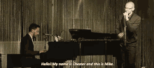 a man playing a piano next to a man singing into a microphone and the man singing is named chester
