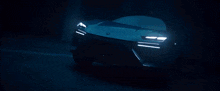 a blue lamborghini car is driving down a dark street