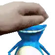 a hand is reaching into a blue vase with a frog in it .