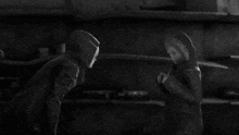 a black and white photo of two people in hoodies standing next to each other