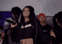 a group of young people are standing around a woman holding a gun .