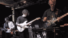 a man playing a guitar next to a keyboard that says korg on it