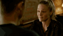a man and a woman are looking at each other and smiling .