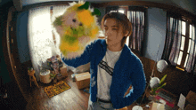 a man in a blue jacket holds a stuffed animal in front of a sign that says punk awake