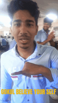 a man in a blue shirt with the words gokul believe your self written above him