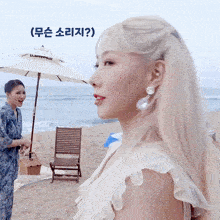 a woman standing on a beach with a white umbrella that says umbrella