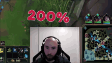 a bald man wearing headphones sits in front of a screen that says ' 200 % ' on it