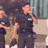 a man in a police uniform is holding a hat