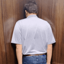 a man is leaning against a wall with his head down
