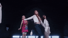 a group of young women are dancing together on a stage .
