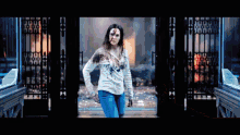 a woman with blood on her face is standing in front of a fire