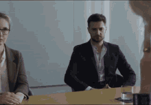 a man and a woman are sitting at a conference table