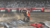 a monster truck is doing a trick in front of lucas oil signs