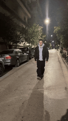 a man walking down a street with cars parked on the side of the road and a license plate that says jc 929