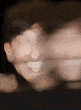 a blurry picture of a person 's face with a smile on it