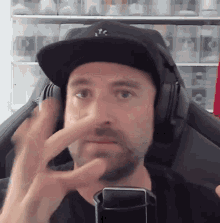 a man with a beard wearing headphones and a hat that says nyc