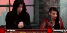 a man and a woman are sitting next to each other in front of a brick wall ..