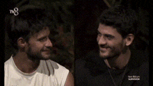 two men are sitting next to each other and smiling for the camera .